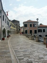 Walkway in city against sky