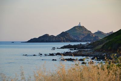 Scenic view of sea and mountains against clear sky