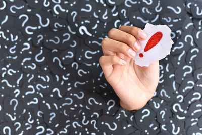 Close-up of woman hand holding heart shape over black background