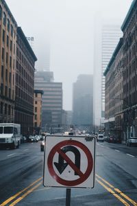 No u turn sign on city street in foggy weather