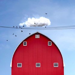 Low angle view of red barn against blue sky