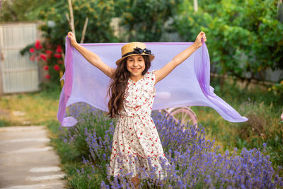 Portrait of smiling young woman standing against plants