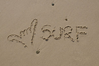 High angle view of text on sand