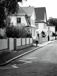 Rear view of woman walking on road