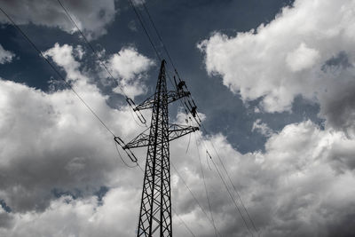 Low angle view of electricity pylon against sky
