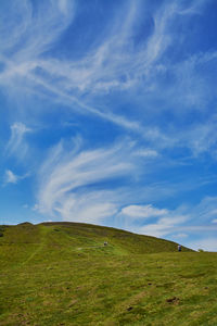 Scenic view of grassy field against cloudy sky