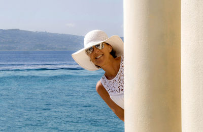 Young woman standing on beach against sky