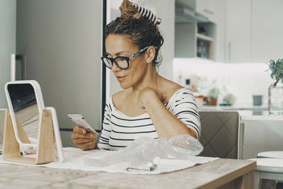 Young woman using mobile phone while sitting at home