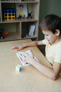 Child playing diy dot game for fingers. useful game for development of childs fingers