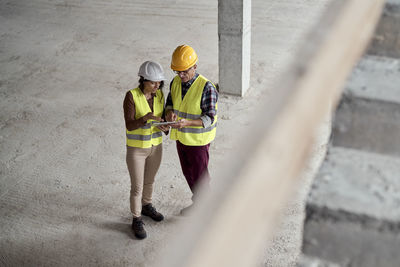 High angle view of engineers brainstorming at construction site