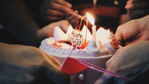 Close-up of hand holding birthday cake