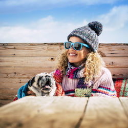 Portrait of woman with dog against sky