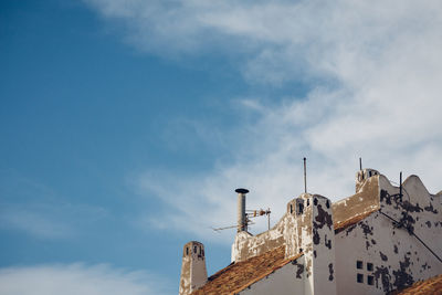 Low angle view of crane against cloudy sky