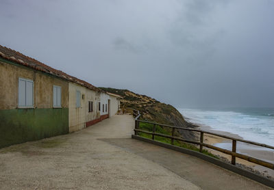 Footpath by sea against sky