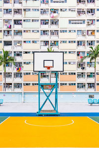 Basketball hoop against buildings in city