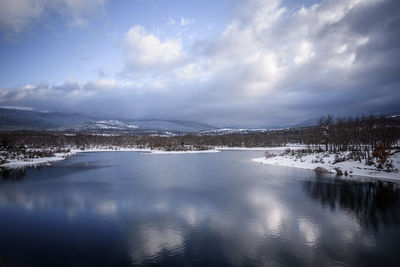 Scenic view of lake against cloudy sky during winter
