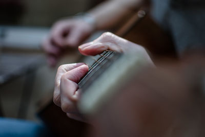 Midsection of man playing guitar