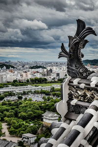 Statue in city against sky