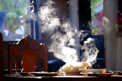 Smoke emitting from tea cup on table in restaurant