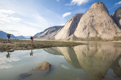 Scenic view of lake by mountain against sky