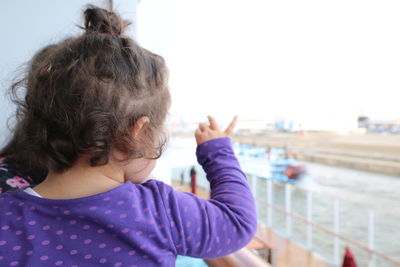 Close-up of girl at beach against sky