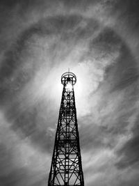 Low angle view of tower against sky and halo of the sun