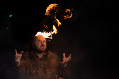 Low angle view of man with fire crackers at night