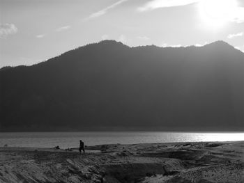 Silhouette people on beach against sky