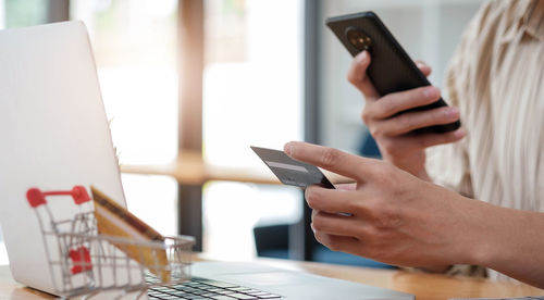 Midsection of man using mobile phone