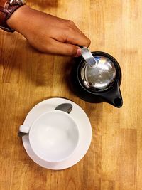 Close-up of man holding coffee cup on table