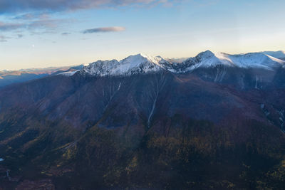 Scenic view of snowcapped mountains against sky during sunset