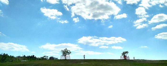 Scenic view of grassy field against cloudy sky