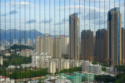 Skyscrapers in city against cloudy sky