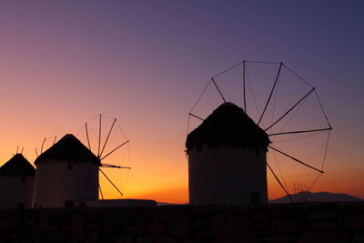 Silhouette of traditional windmill against sky during sunset