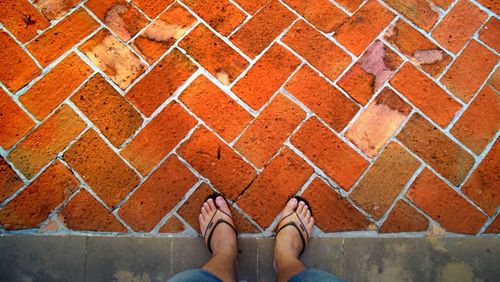 Low section of woman standing on cobblestone