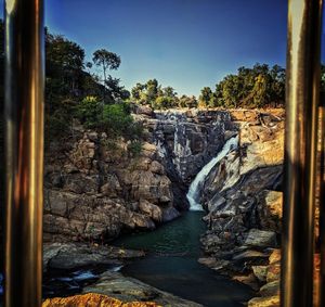 View of rocks in water against sky