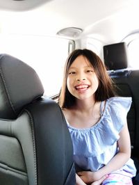 Portrait of happy girl sitting in car