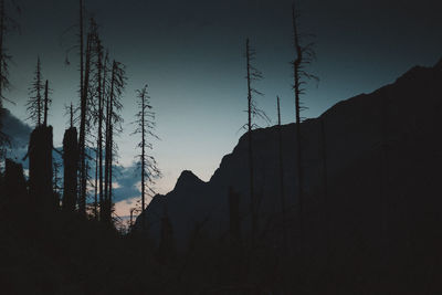 Low angle view of silhouette mountains against clear sky