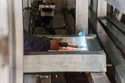 Cropped image of welder working in factory