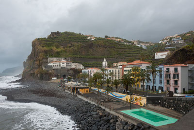 Houses by swimming pool against sky in city