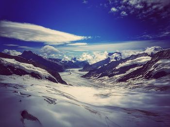 Scenic view of snow mountains against blue sky