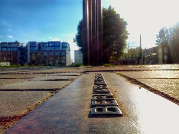 Close-up of railroad track by road against sky