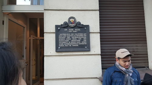 Portrait of young man wearing hat against wall