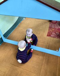 Reflection of baby boy on mirror at home