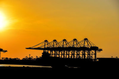 Silhouette pier over sea against sky during sunset