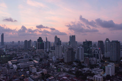 Aerial view of buildings in city against sky during sunset