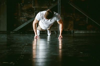 Muscular man doing push-ups at home