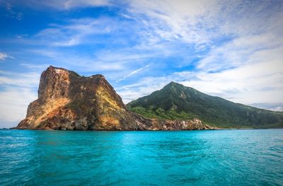 Scenic view of sea and mountains against sky