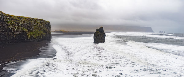 Scenic view of snow covered shore against sky