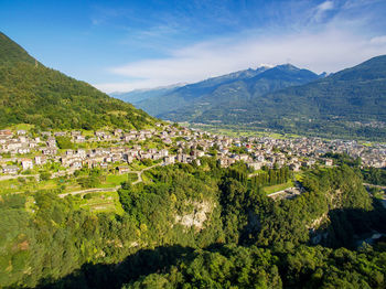 Aerial view of townscape and mountains against sky